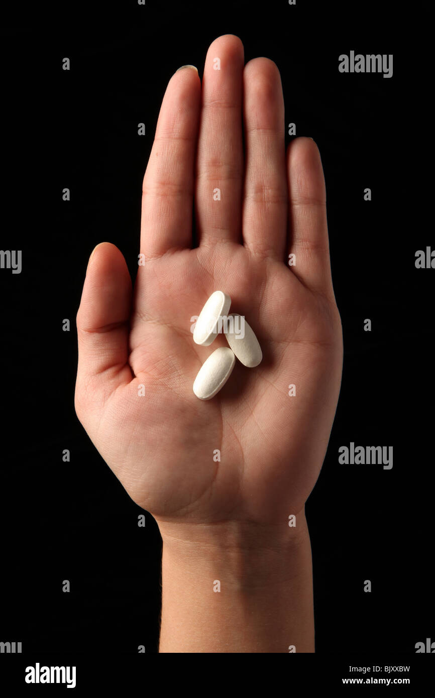 Eine weibliche Frau Hand hält drei Pillen in der Handfläche von ihrer hand Stockfoto