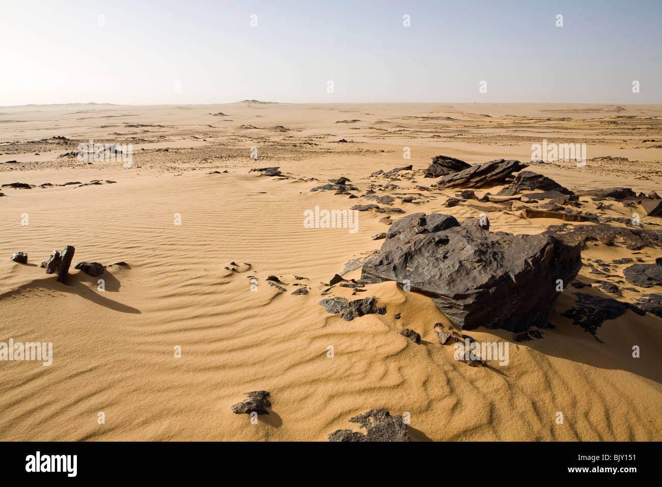 Schwarzen Felsen im Wüstenboden im Gilf Kebir Nationalpark, westliche Wüste, Ägypten Stockfoto