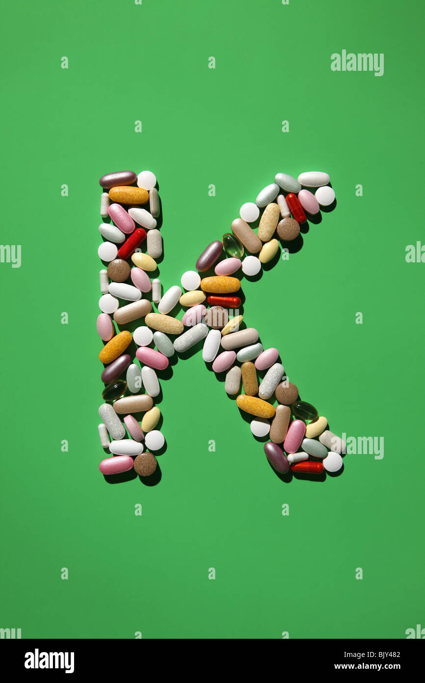 Die Form des Buchstabens K gebildet mit vielen bunten Pillen, Tabletten und Kapseln Stockfoto
