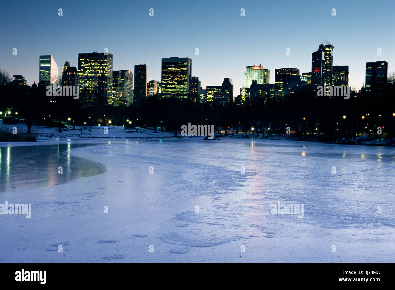 Midtown Manhattan, wie aus dem gefrorenen See im Central Park in New York an einem kalten Winterabend. Stockfoto