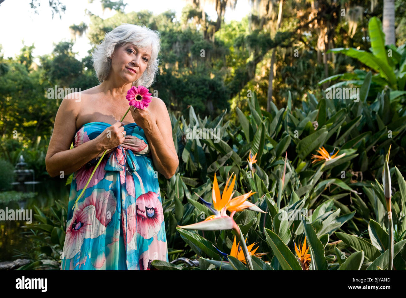 Sexy Reife Frau in einem trägerlosen Kleid Ruf im tropischen Garten  Stockfotografie - Alamy