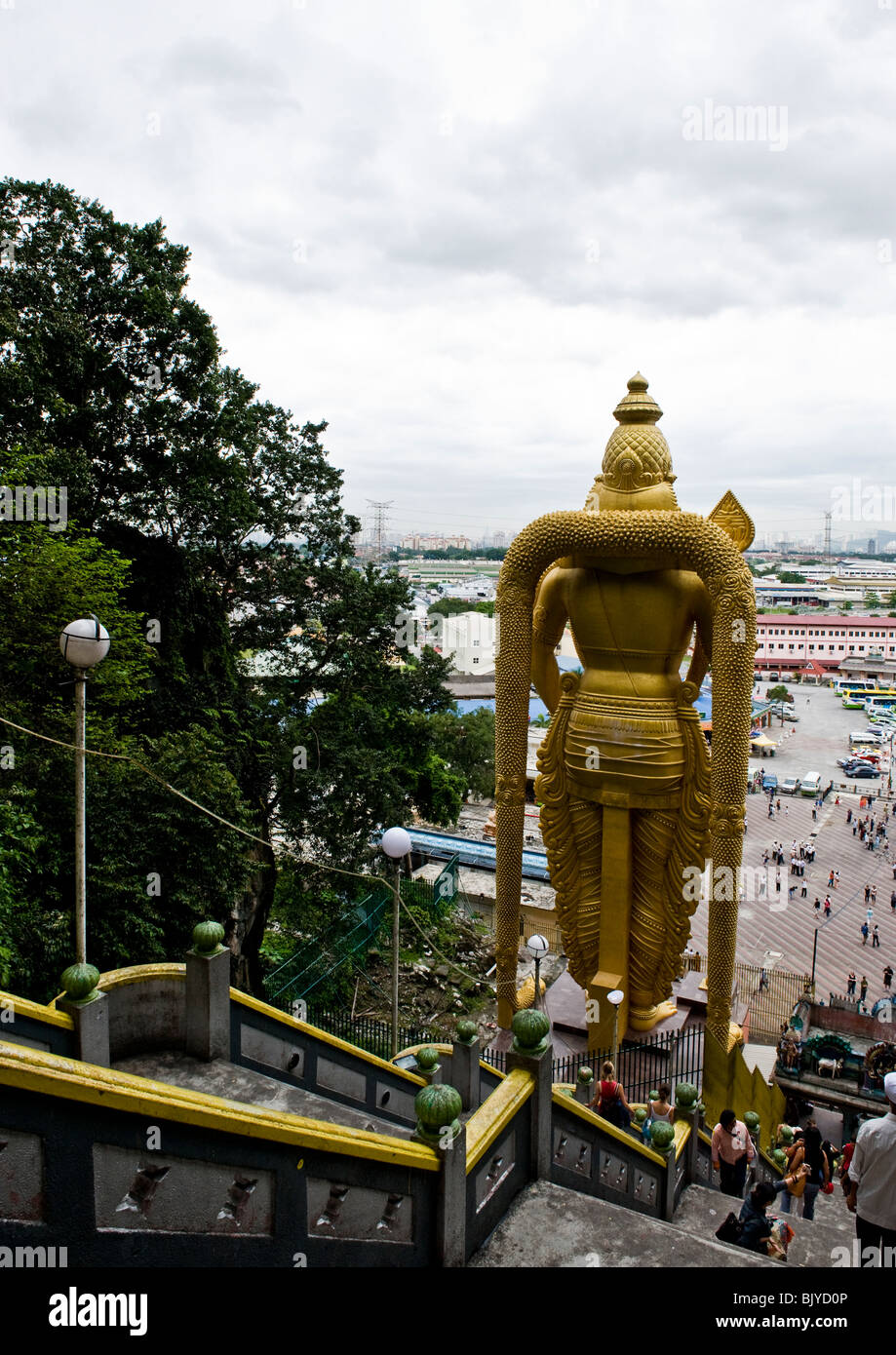 Rückseite der riesige goldene Statue von Lord Murugan mit Vordergrund Innenhof und Touristen wie vom Eingang des Batu-Höhlen zu sehen. Stockfoto