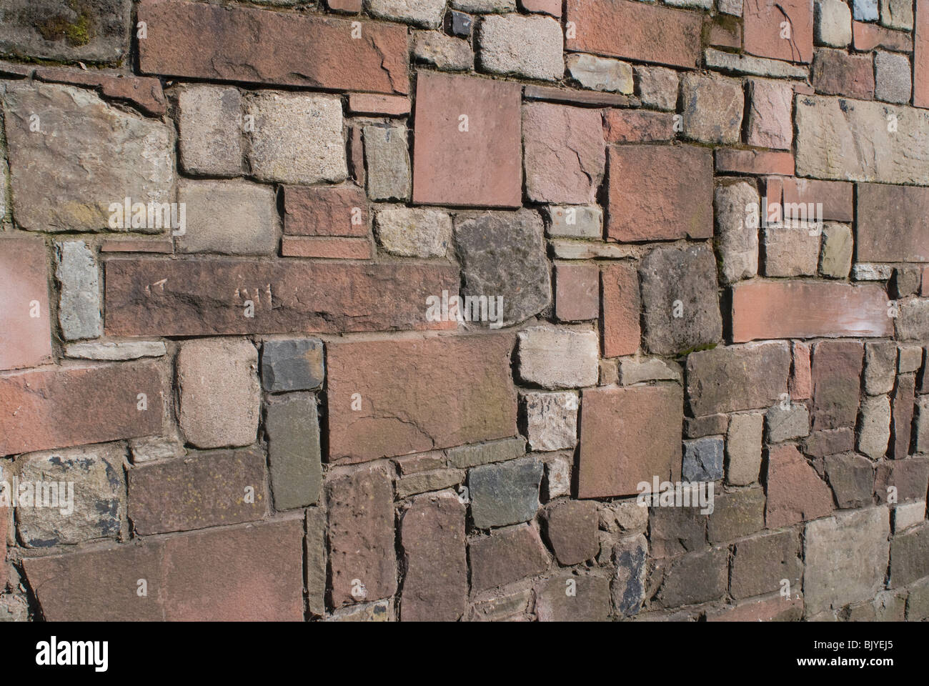 Eine solide Stein Wand aus Sandstein, Kalkstein und Granit. Stockfoto