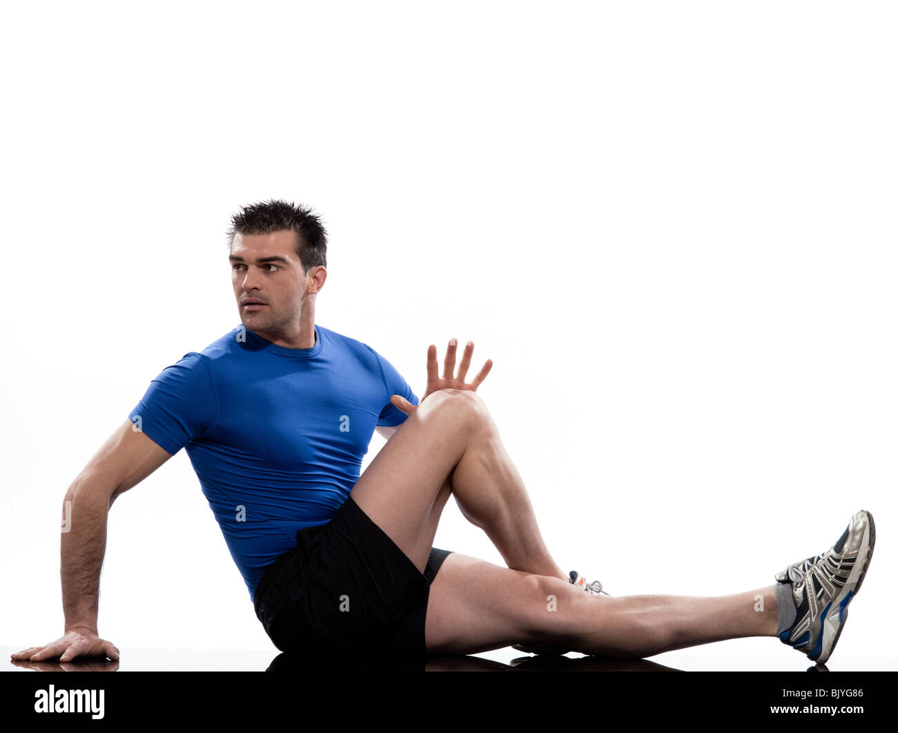 Mann auf die Bauchmuskeln Drehung Training Körperhaltung auf weißem Hintergrund. Sitzen Sie, Strecken Sie ein Bein und beugen Sie dem andern. Halten Sie die Knie und bringen Sie es zu Ihnen für 10-20 Sekunden. Lösen und wechseln. Stockfoto