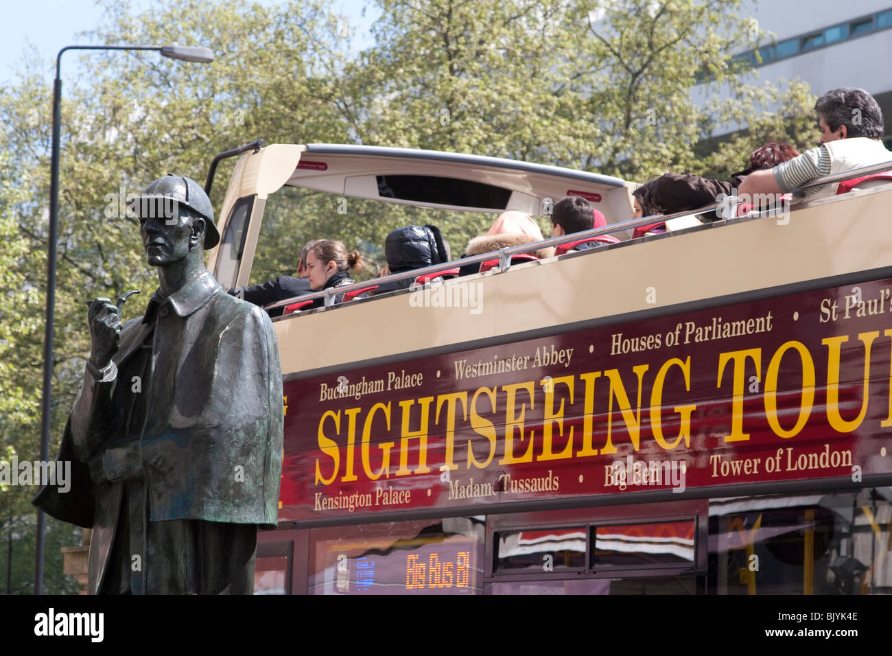 Eine Sightseeing Tour-Bus an der Baker Street Station mit Sherlock Holmes-Statue in schehens Stockfoto