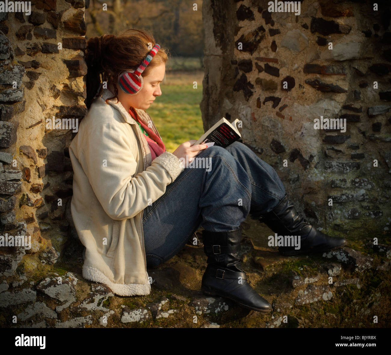 Mädchen-Lesebuch in einem verfallenen Kloster. Stockfoto