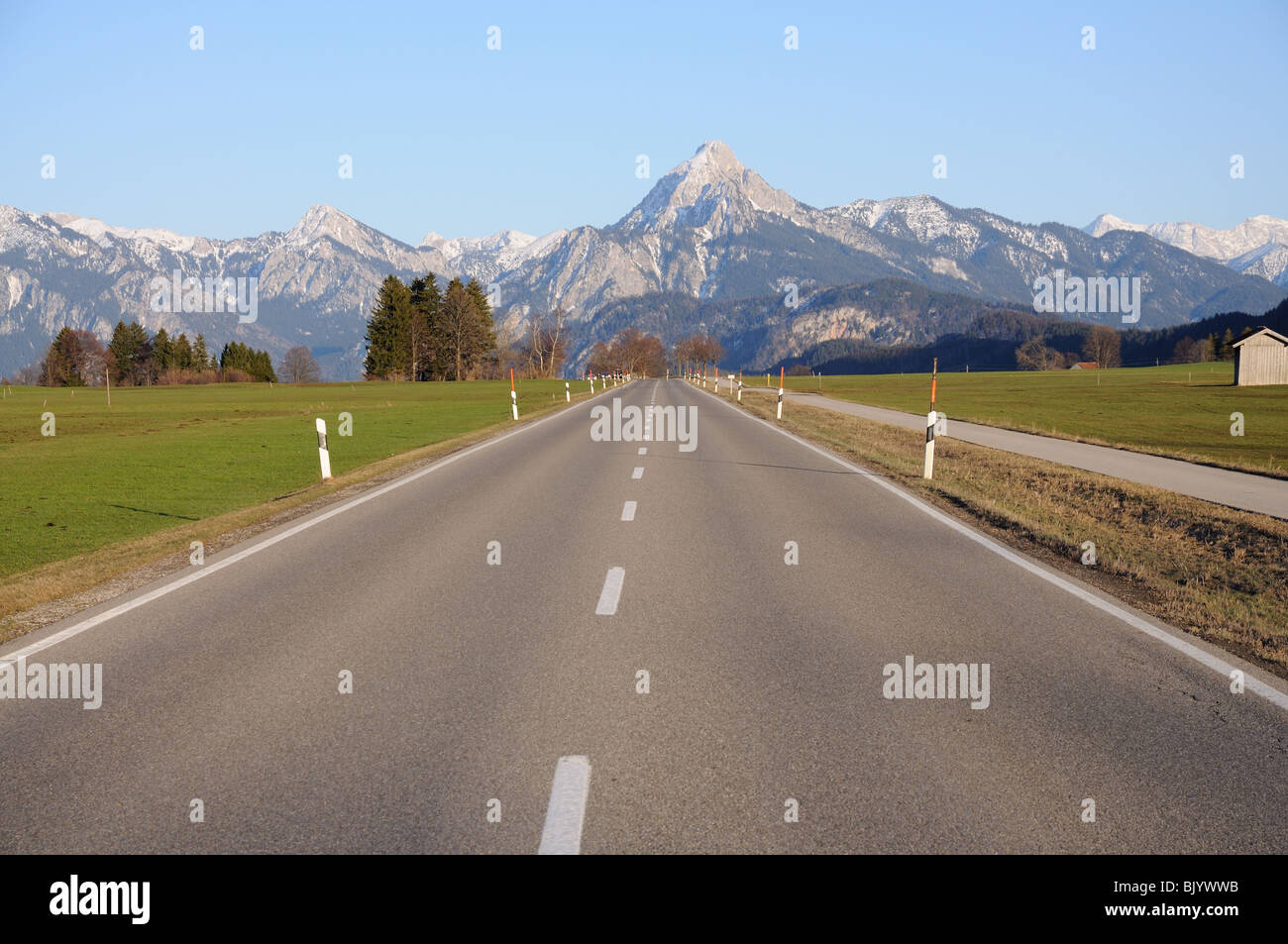 Straße führt bis zu den Alpen, Bayern Stockfoto