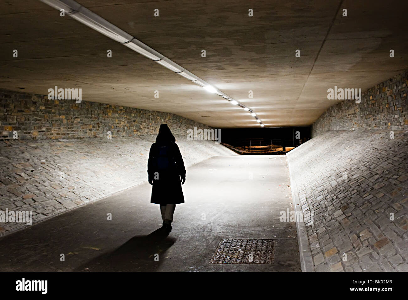 Frau allein zu Fuß durch die Unterführung in der Nacht Abergavenny Wales UK Stockfoto