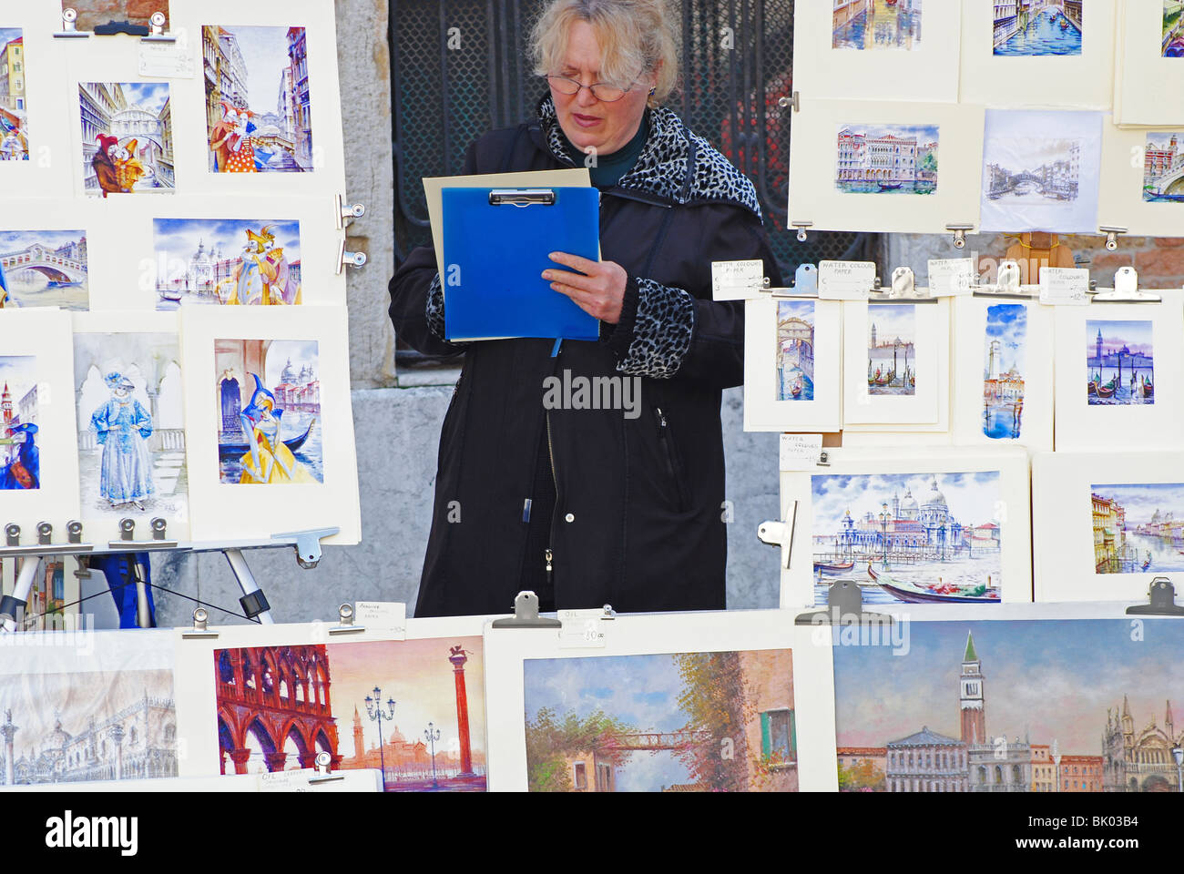 Eine Frau verkauft Gemälde für Touristen in Venedig, Italien Stockfoto