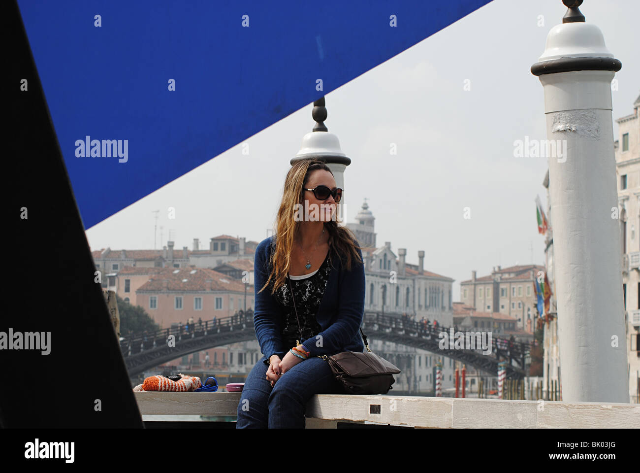 Eine Mädchen sitzt auf einem Zaun durch den Canal Grande bei der Peggy Guggenheim Collection in Venedig, Italien Stockfoto