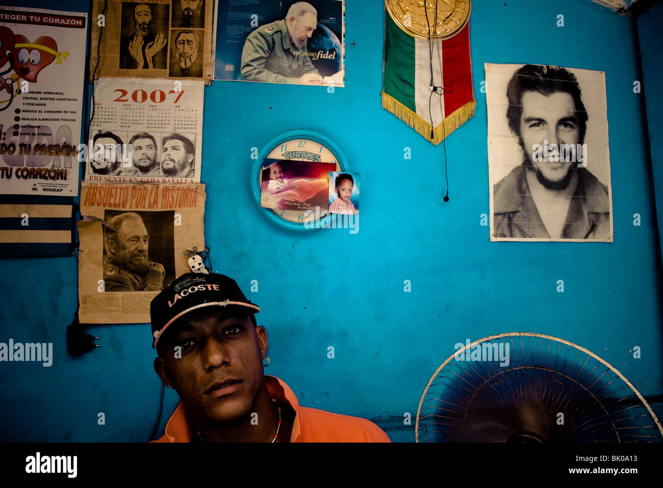 Ein kubanische Uhrmacher arbeitet vor einer Wand fallenden Bilder der kubanischen Revolutionäre Führer in Havanna, Kuba. Stockfoto