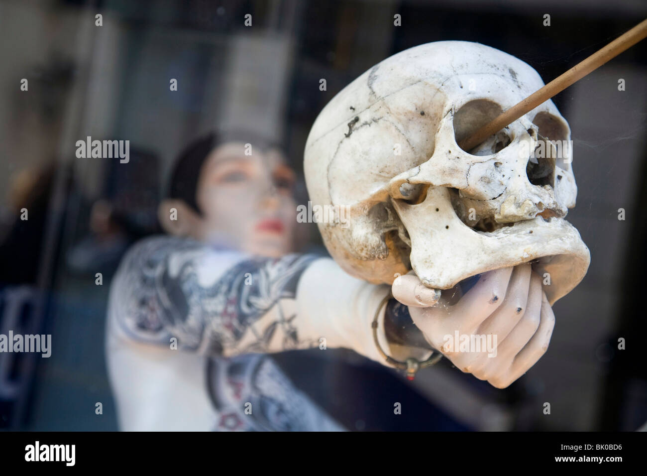 Fenster In Einem Tattoo Shop In Hastings Ein Manequin Halt Einen Schadel Mit Einem Pfeil Durch Das Auge Auf Konig Harold 1066 Stockfotografie Alamy