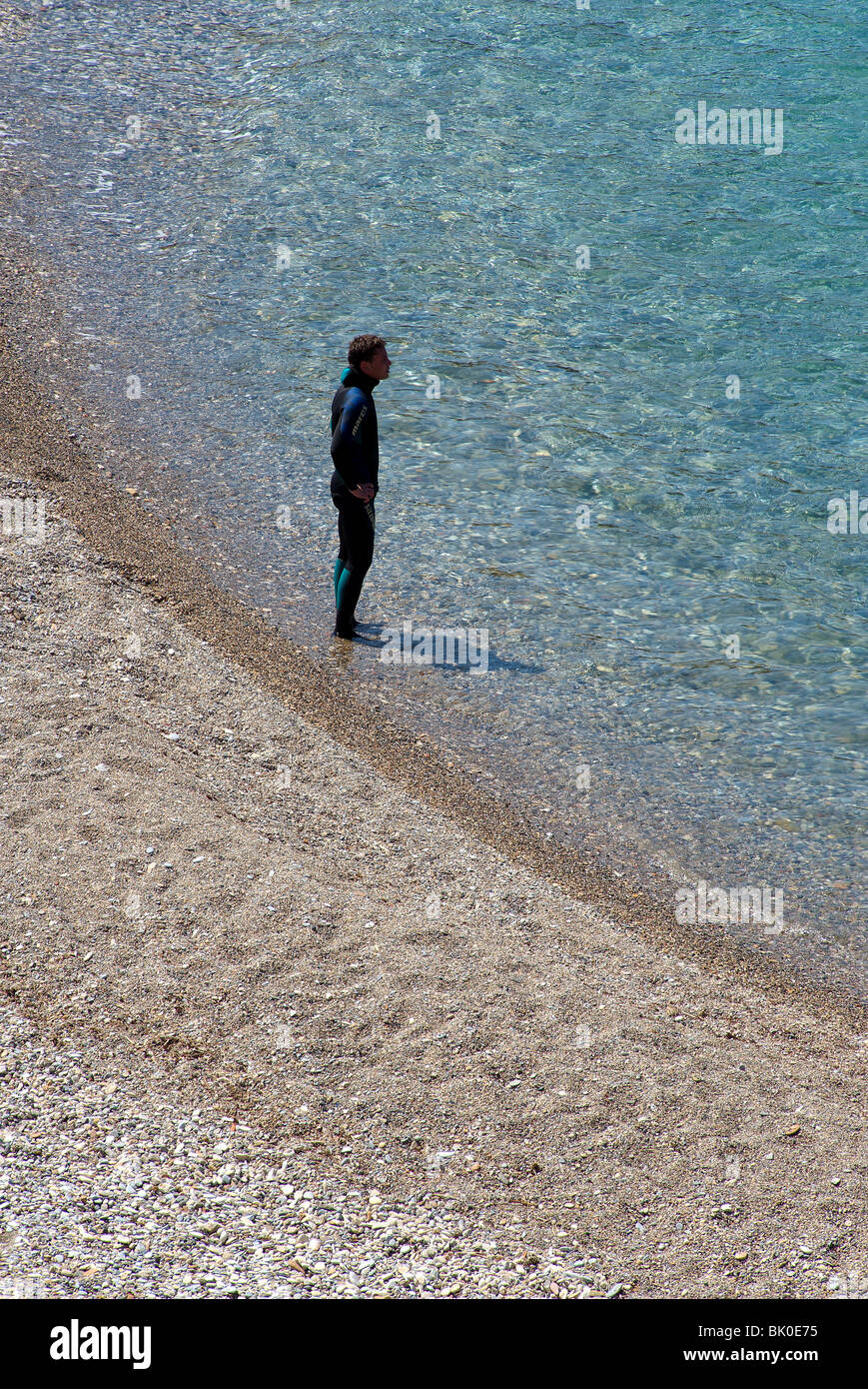 Junger Mann in einem Anzug steht im Meer Stockfoto