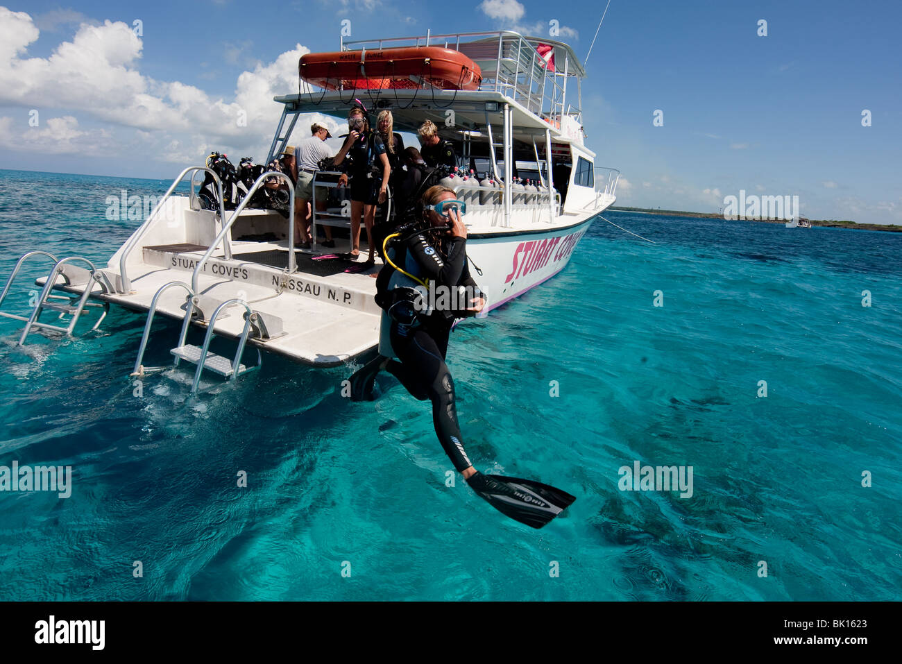 Scuba Diver gelangt Wasser vom Boot über großen Schritt Eintrag. Stockfoto