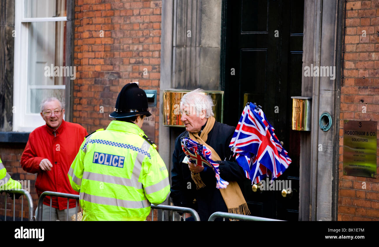Eine UK-Polizist plaudert mit einem Gentleman Flagge Verkäufer bei einer Veranstaltung in Derby, wo die Königin ist, zu besuchen. Stockfoto
