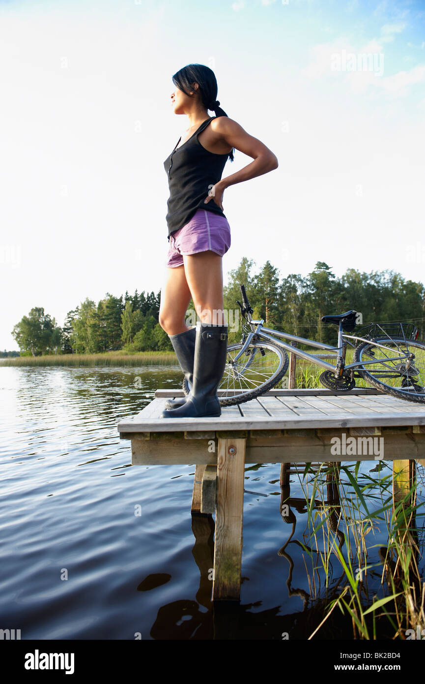 Frau mit Fahrrad, am Ende eines Docks Stockfoto