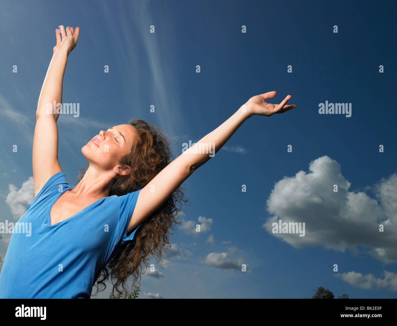 Frau, die ihre Arme gen Himmel zu verbreiten Stockfoto