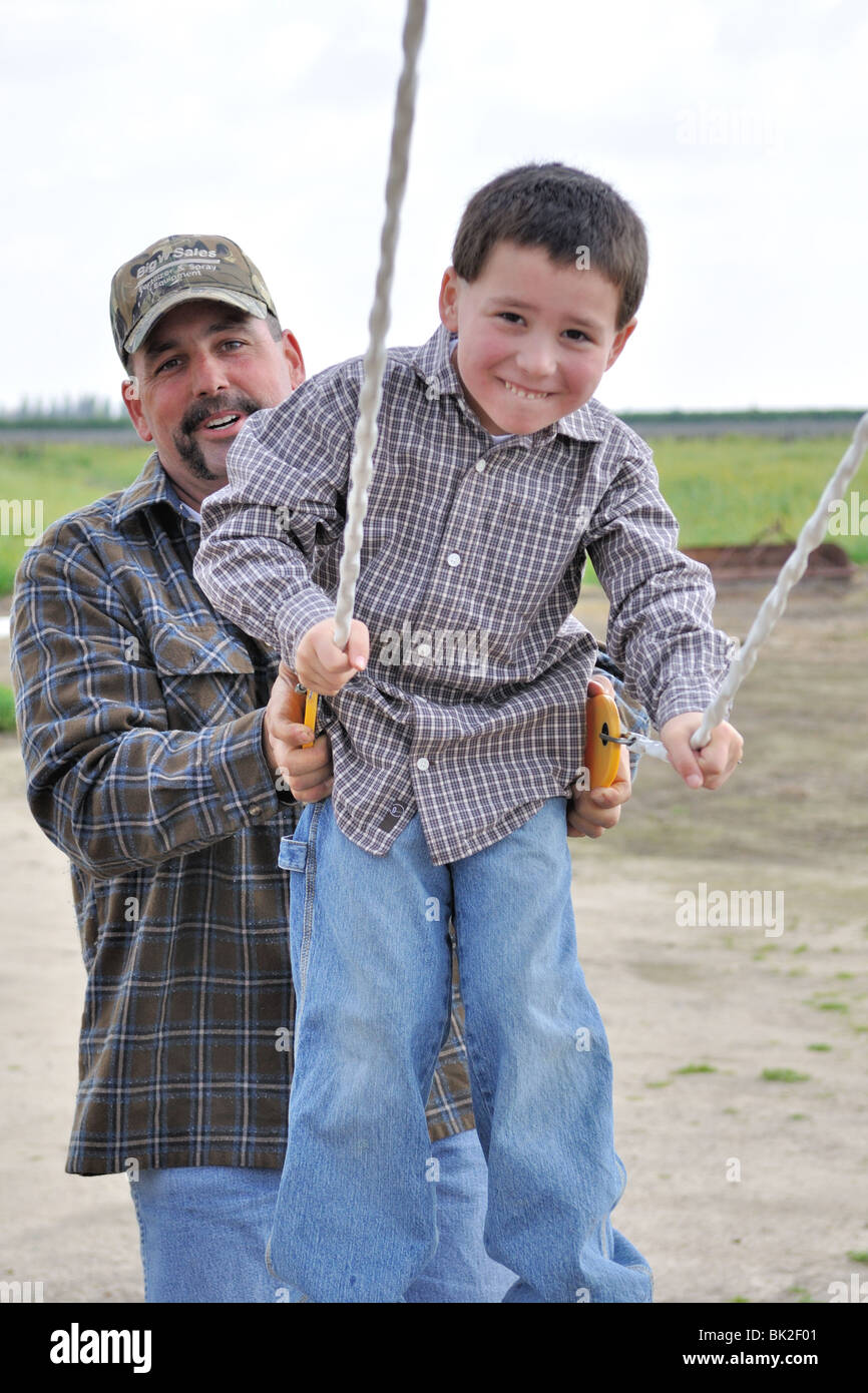 Nathaniel Bonomi, 5, Swingen, bekommt einen Schub von seinem Vater Brett Bonomi Stockfoto