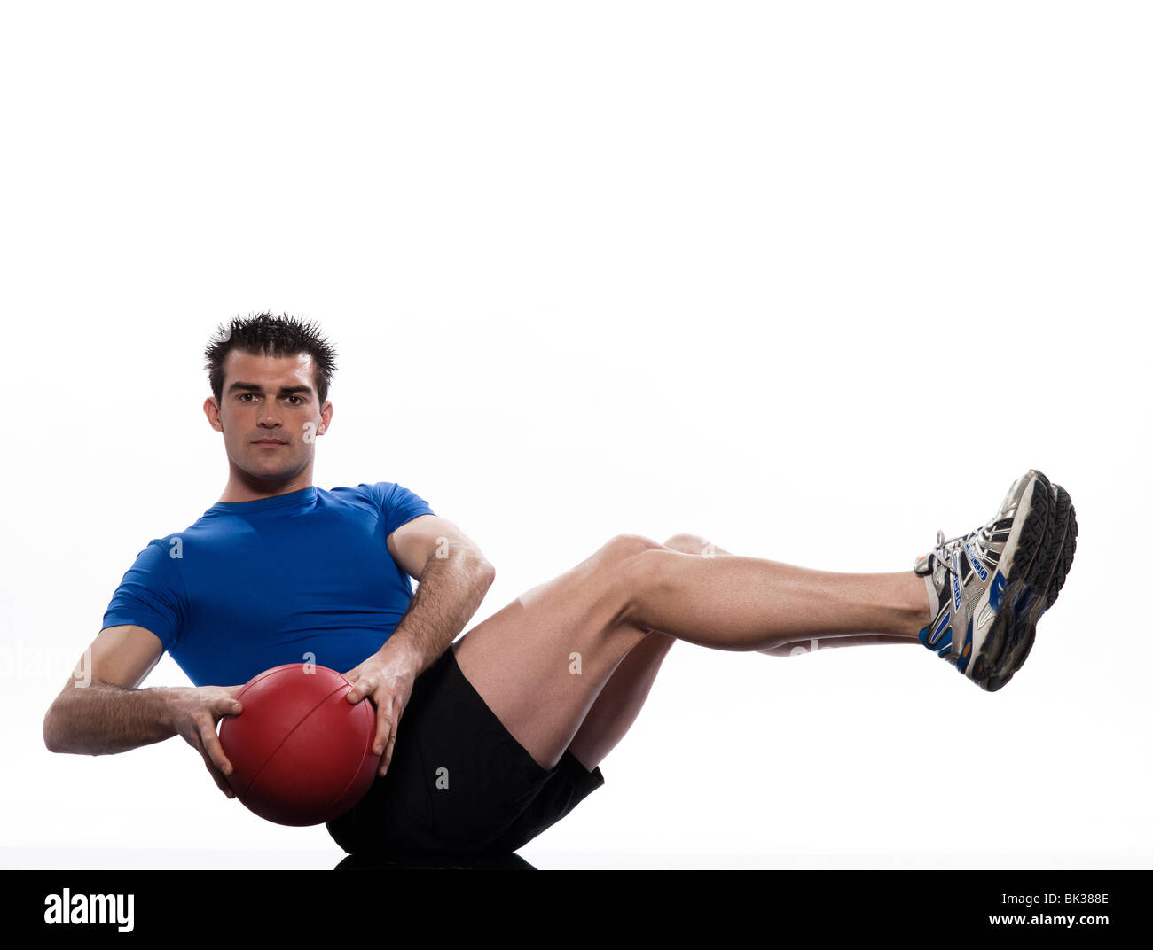 Mann hält Fitnessball Worrkout Haltung Übung Bauchmuskeln trainieren Körperhaltung auf weißem Hintergrund Studio isoliert Stockfoto