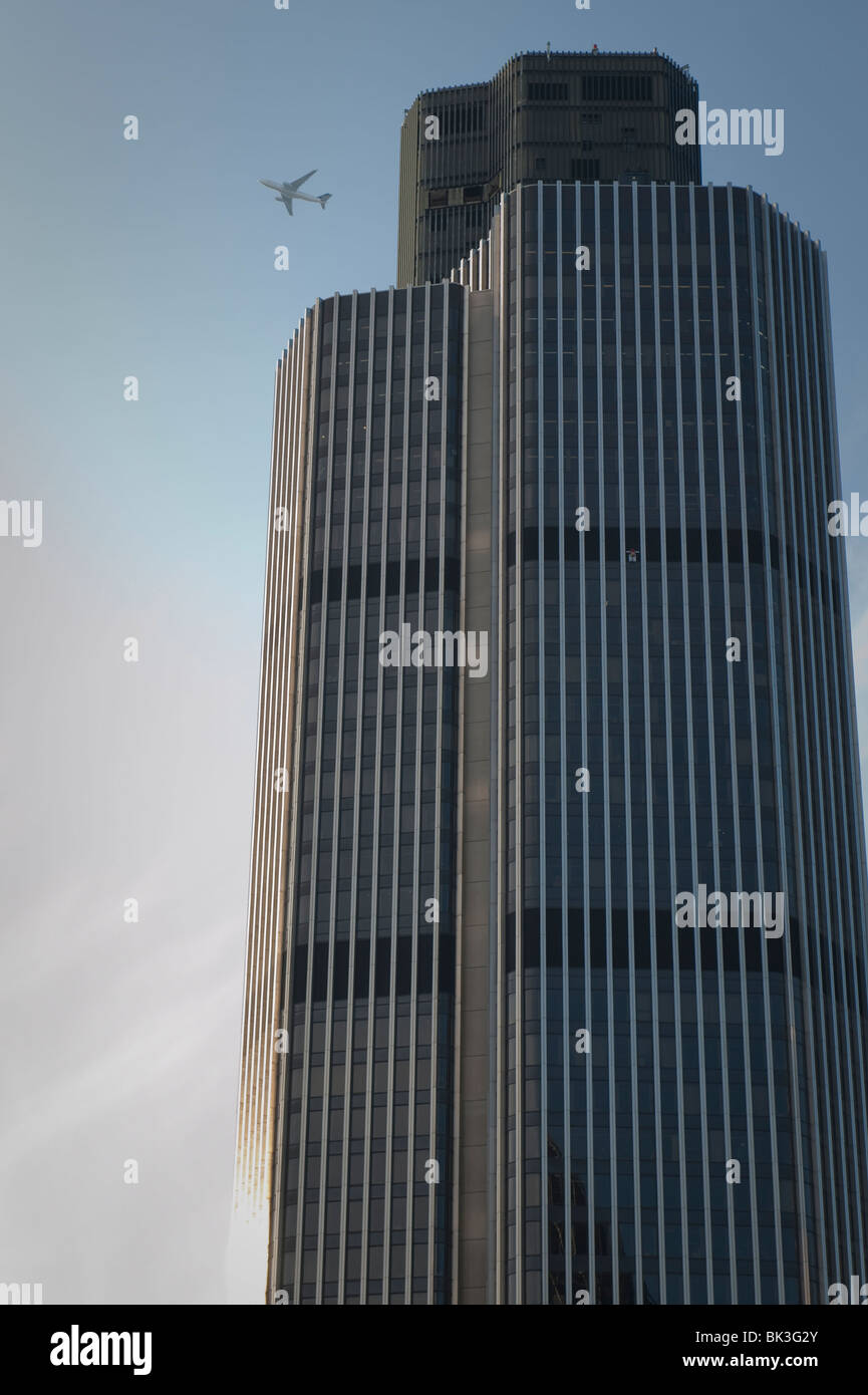 Ein Flugzeug in der Nähe eines Wolkenkratzers Gebäude in London. Stockfoto