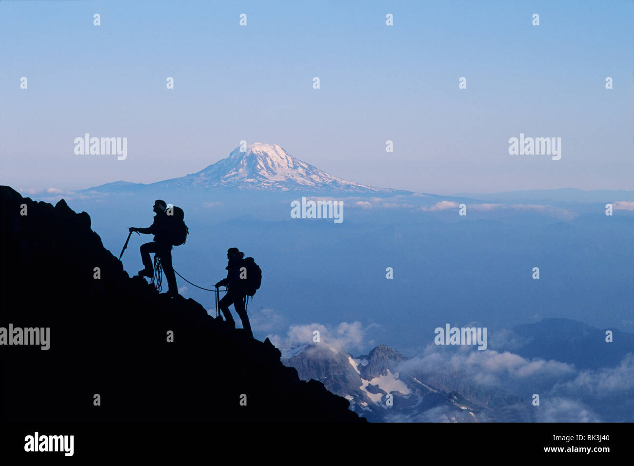 Zwei Kletterer aufsteigend Mount Rainier mit Mount Adams am Horizont, Mount-Rainier-Nationalpark, Washington. Stockfoto