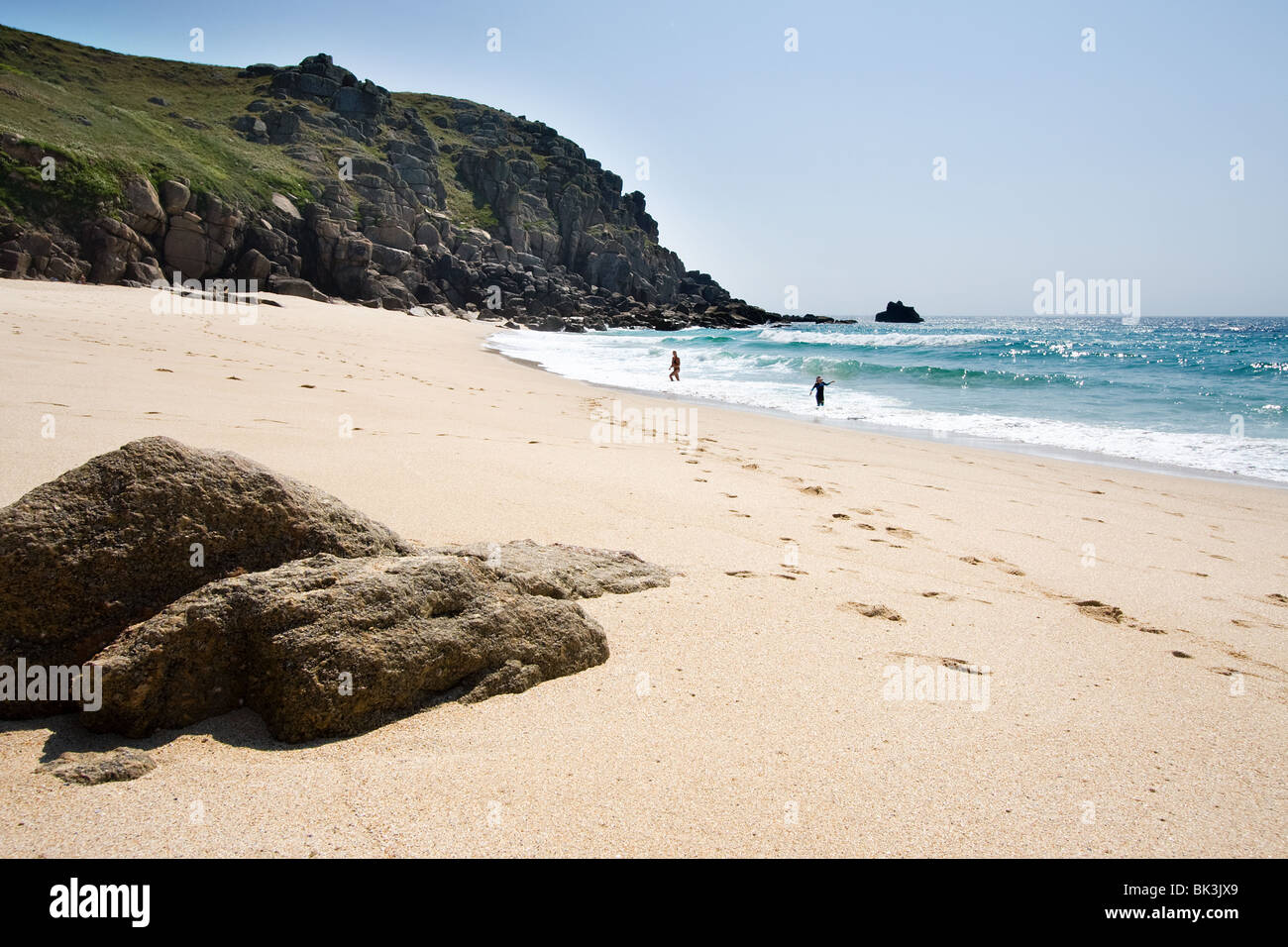 zwei Menschen spielen im Meer an einem einsamen Strand, Cornwall, uk Stockfoto