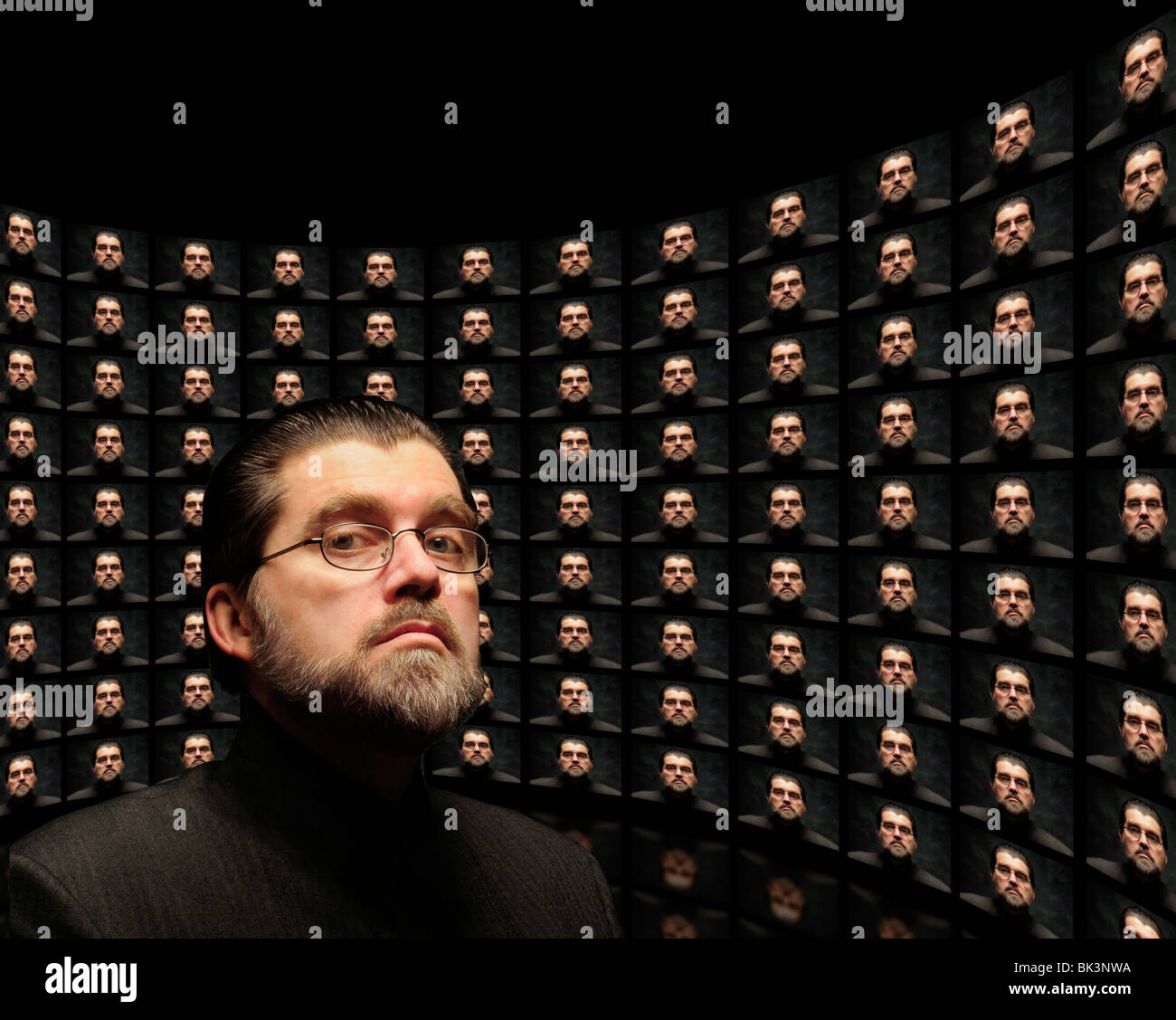 Mehrerer Indoktrination Monitore zeigen gleiche ominösen Orwellschen Mann mit demselben Mann im Vordergrund Stockfoto