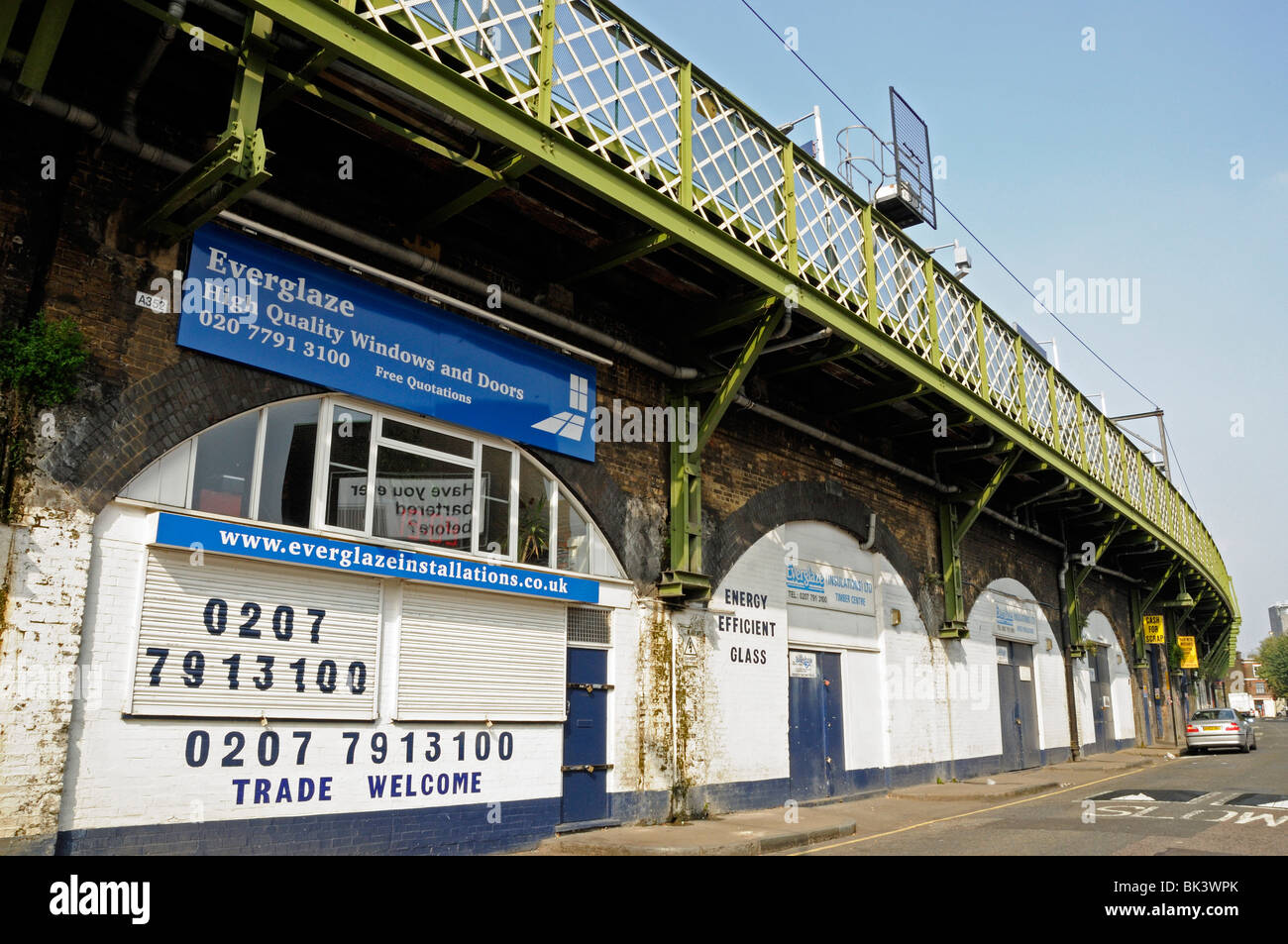 Kleinen Verglasung Geschäft befindet sich unter Bahnbögen in Pappel East London England UK Stockfoto