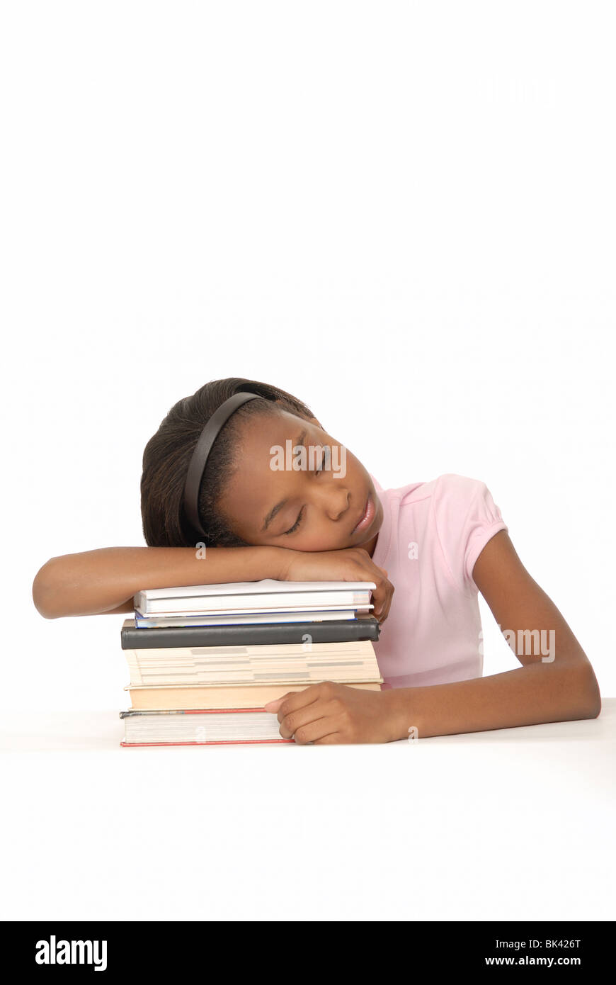 Zehn Jahre Alter Student stützte sich auf einen Stapel Bücher und einschlafen. Stockfoto