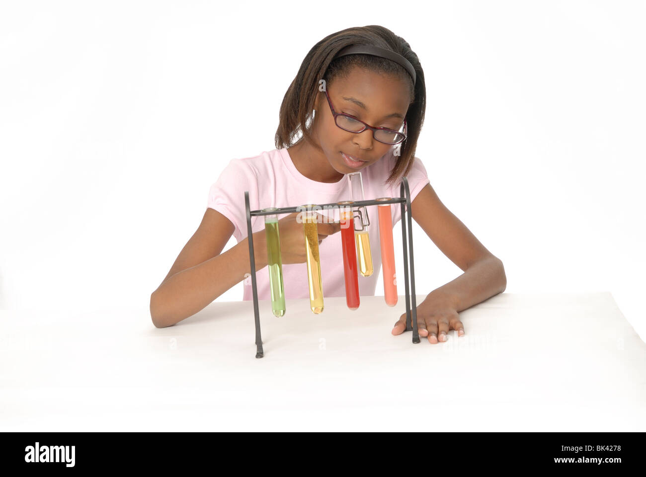 Zehn Jahre altes Mädchen, ein Student, eine wissenschaftliches Experiment mit Becher gefüllt mit bunten Flüssigkeit zu tun. Stockfoto