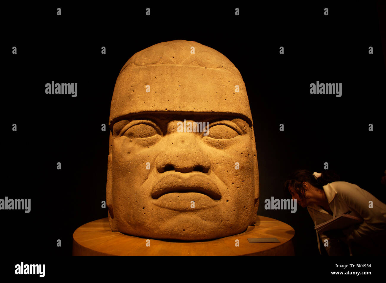 Ein Student schaut ein riesiger Stein Kopf, wie sie das Nationalmuseum für Anthropologie in Mexiko-Stadt Besuche Stockfoto
