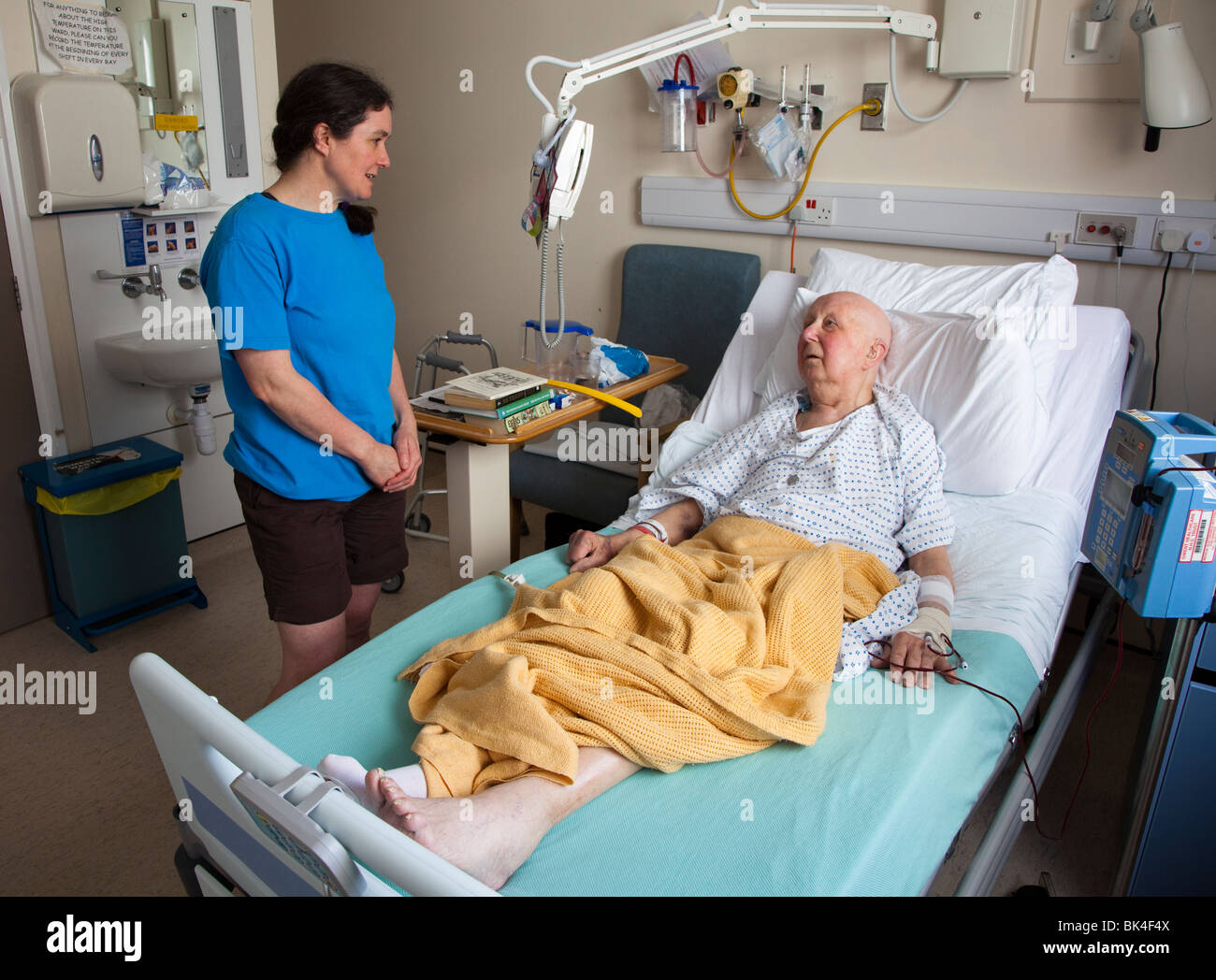 Patienten im Krankenhausbett mit Besucher Wales UK Stockfoto