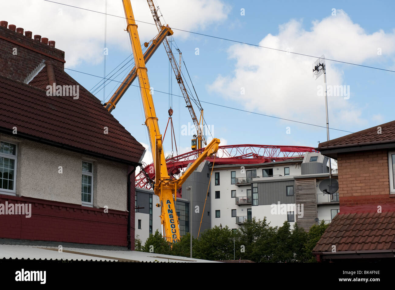 Turmdrehkran brach gefallenen auf Dach der Wohnblock wird von einem anderen Kran abgehoben Stockfoto