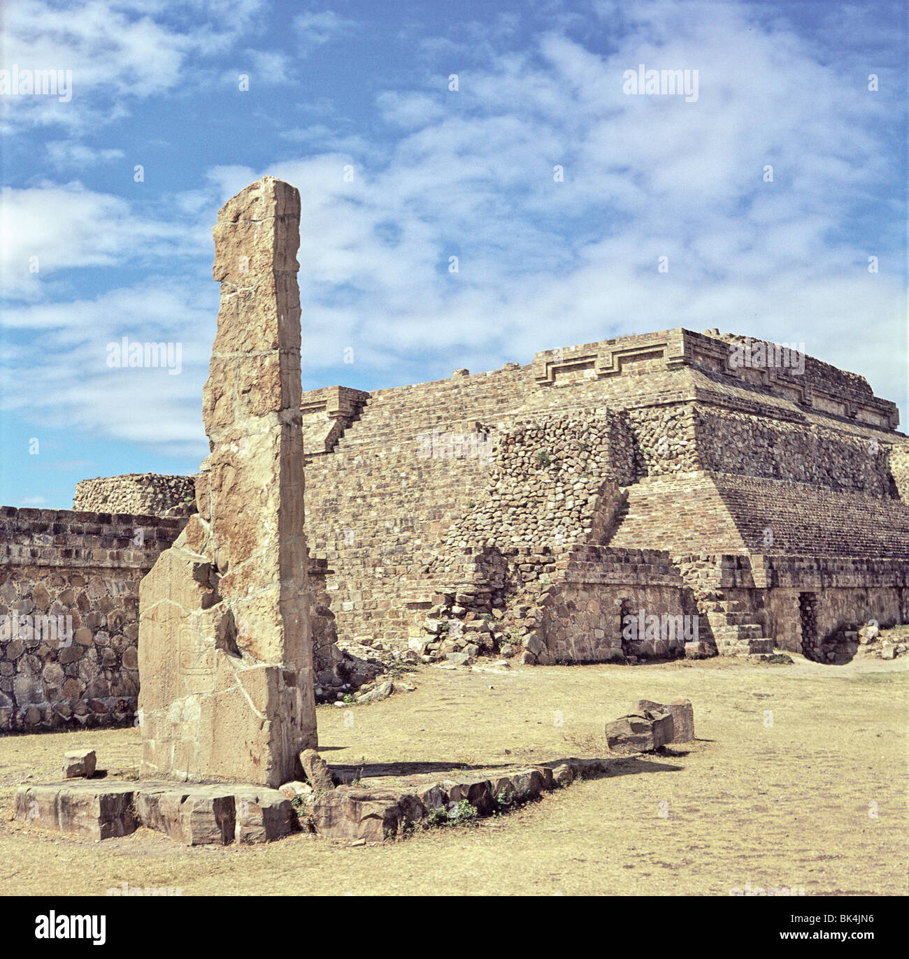 Monolithische Säule und Pyramide auf die präkolumbische Stätte von Monte Alban im Bundesstaat Oaxaca, Mexiko Stockfoto