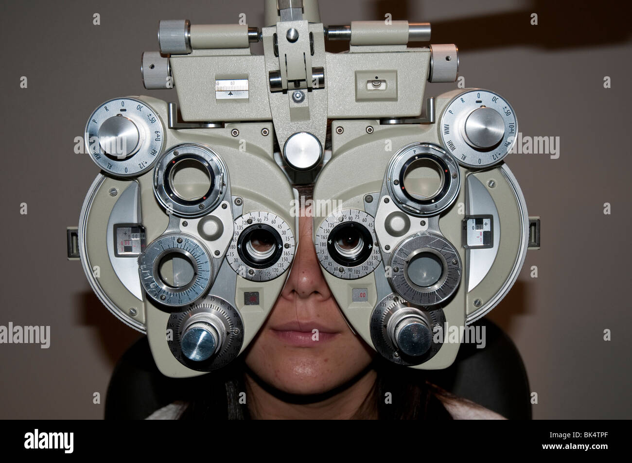 Teenager-Mädchen haben ihre Augen überprüft für Kontaktlinsen Verschreibung von einem Augenarzt mit einem Gerät namens einen phoropter Stockfoto