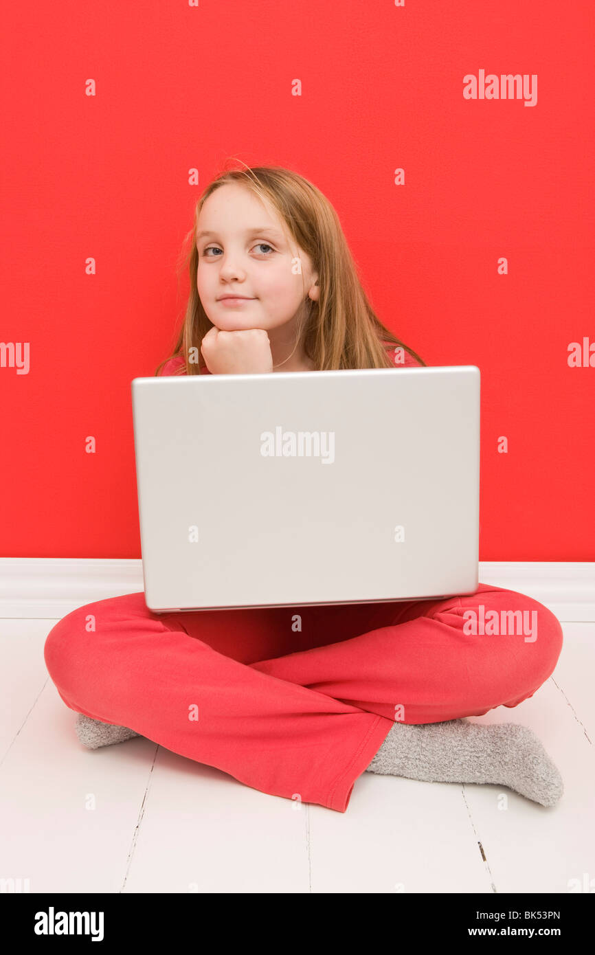 Porträt von Mädchen sitzen am Boden mit Laptop-Computer Stockfoto