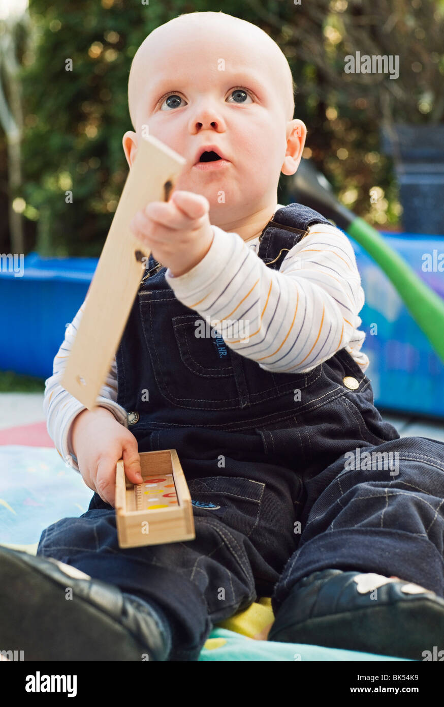 Junge sitzt im Garten, spielen mit Holzbauklötzen Stockfoto