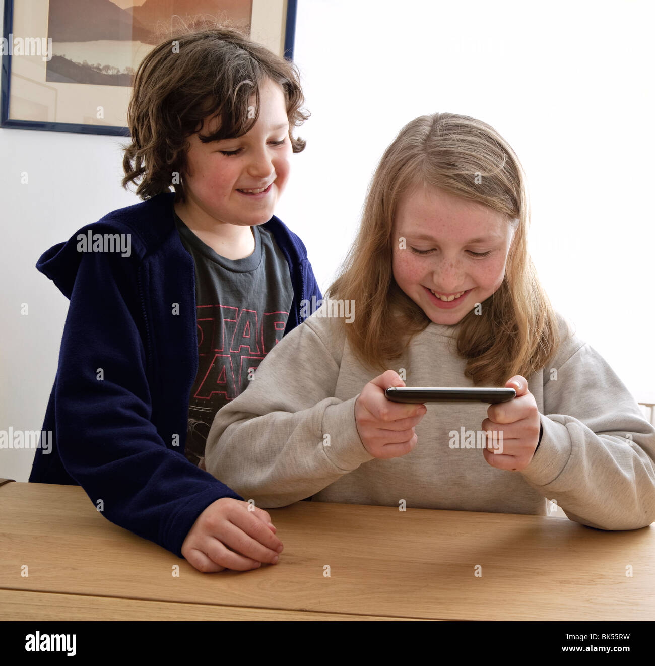 BRUDER UND SCHWESTER MIT IPOD/IPHONE SPIELEN Stockfoto