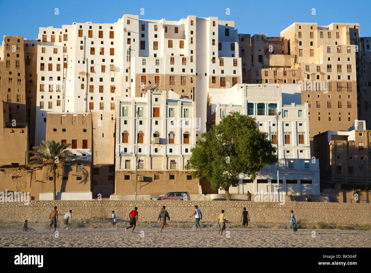 Junge Menschen spielen Fußball (Fußball) in ein UNESCO gelisteten Erbe Stadt Shibam, Jemen berühmt für seinen schlammigen Hochhäuser. Stockfoto