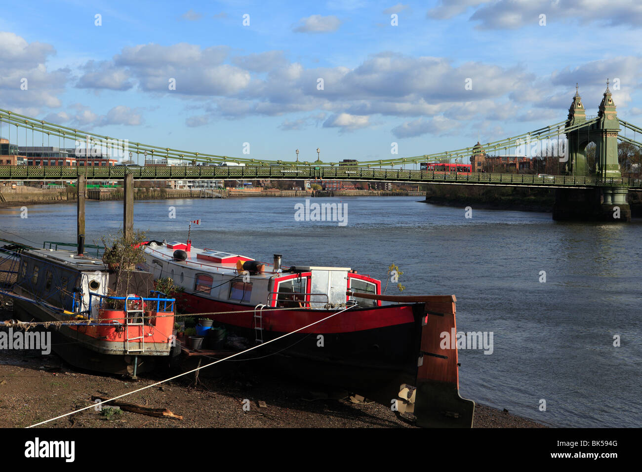 Vereinigtes Königreich West London Hammersmith Bridge mit Hausbooten im Vordergrund Stockfoto