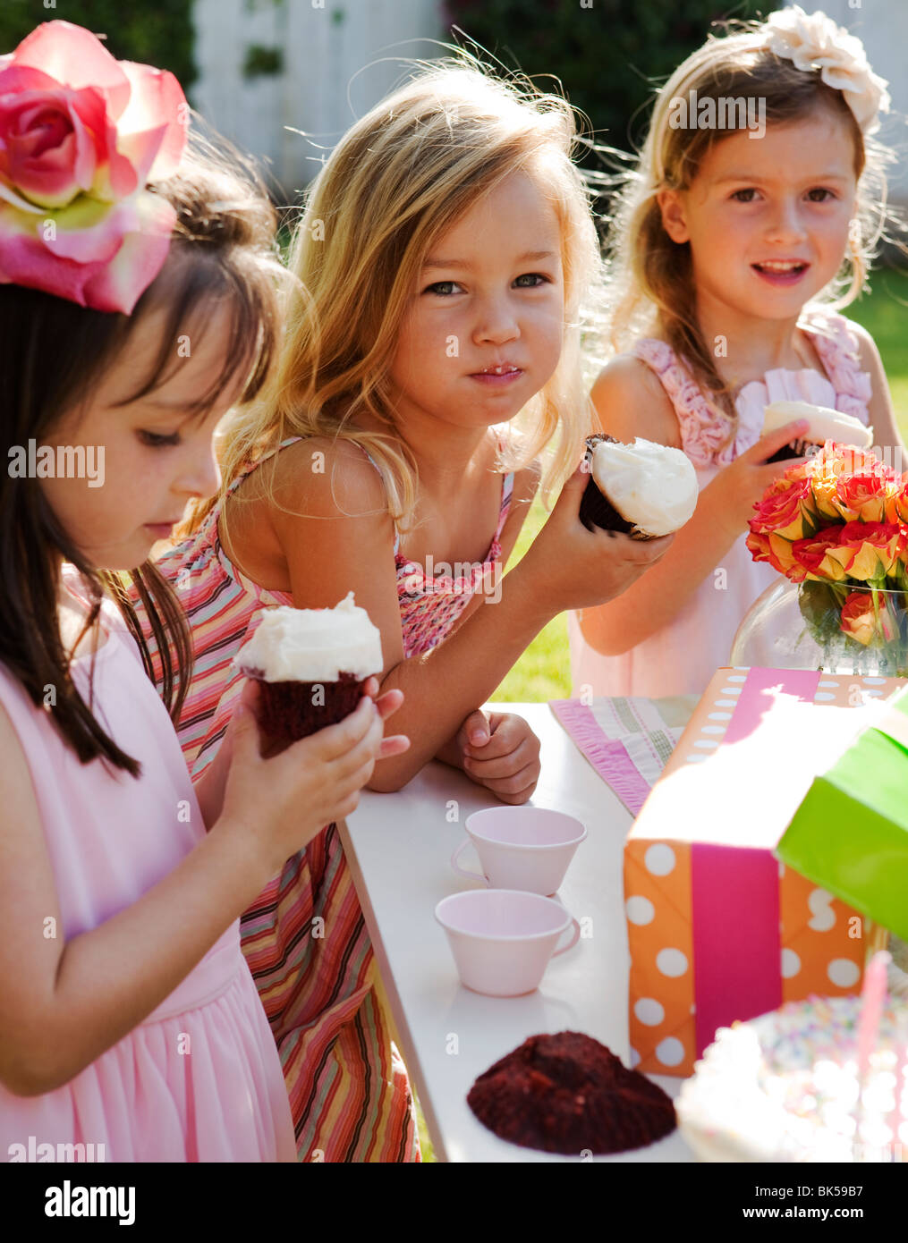 Junge Mädchen essen Muffins bei einer Geburtstagsparty Stockfoto