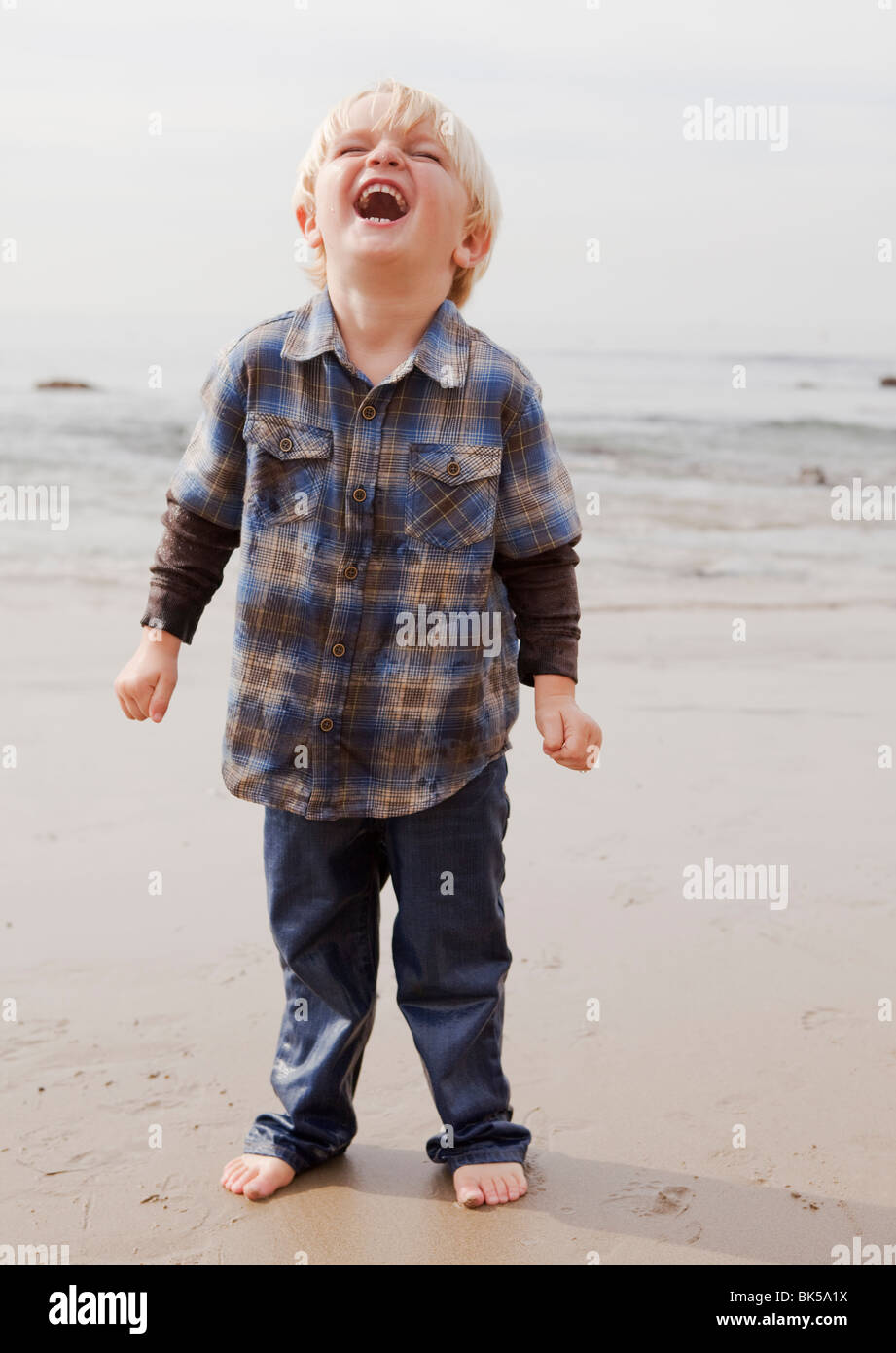 Junge am Strand lachen Stockfoto