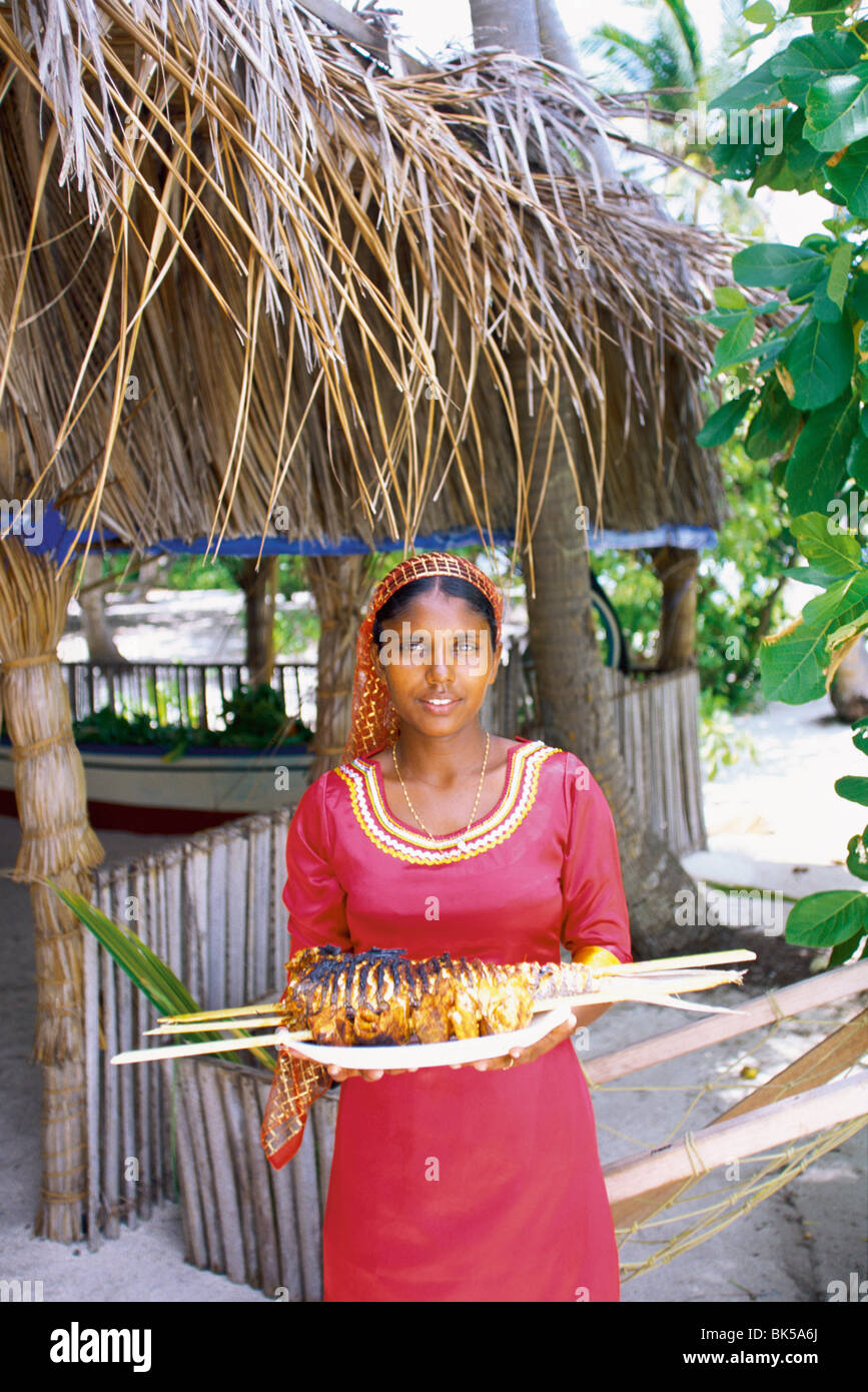 Maledivischen Frau bietet einen Teller mit gegrilltem Fisch, Malediven, Indischer Ozean, Asien Stockfoto