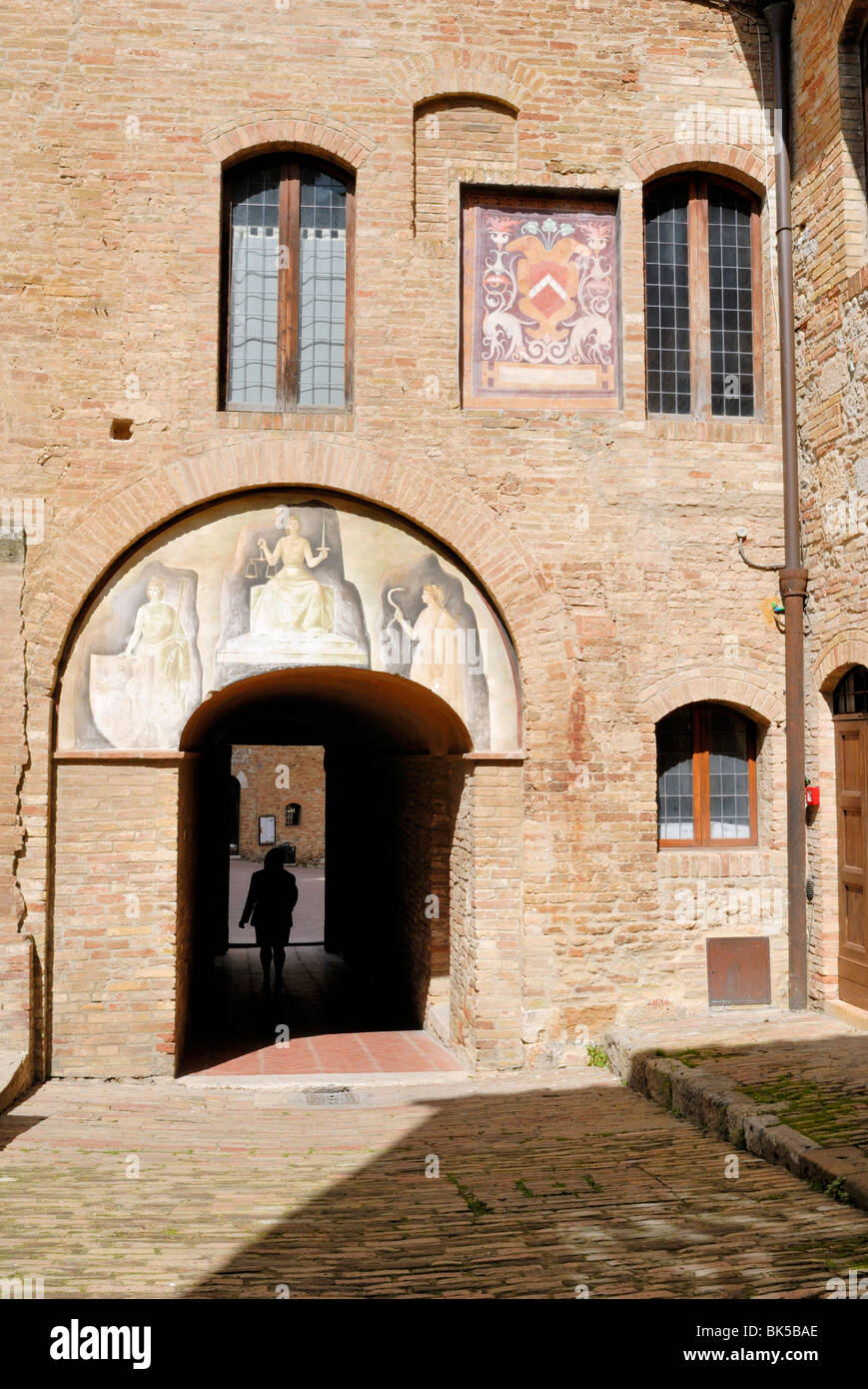 Die abgenutzten Fresken im Innenhof des Palazzo del Popolo. Palazzo del Popolo, Piazza del Duomo, San Gimignano, Toskana... Stockfoto