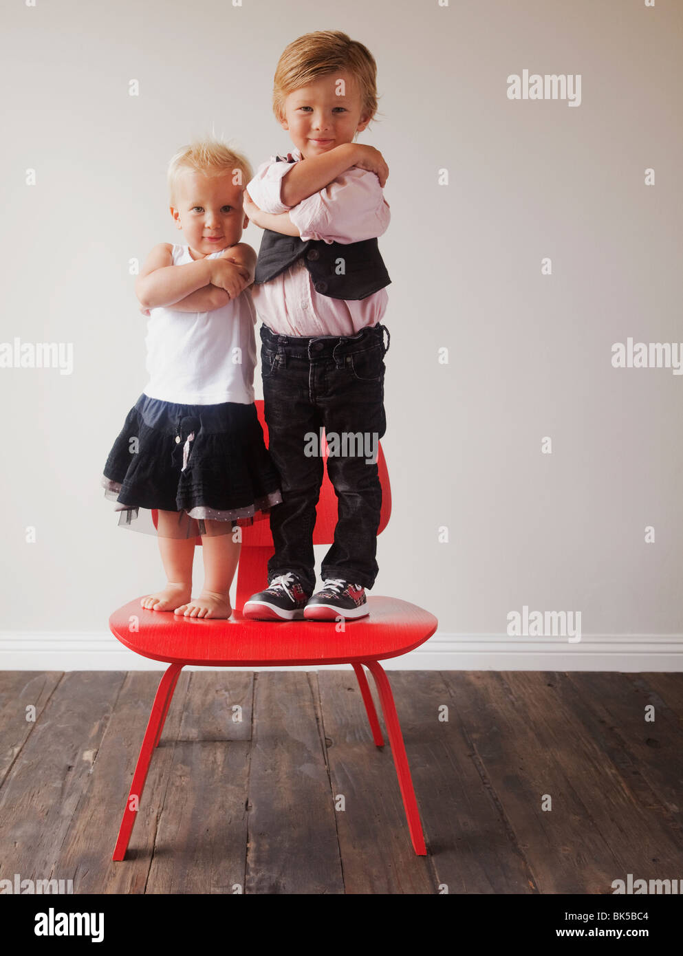 Kinder stehen auf roten Stuhl Stockfoto