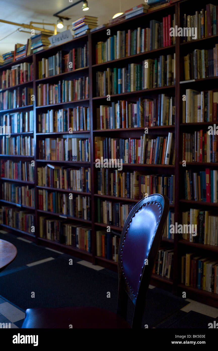 Hohen Bücherregale hinter leeren Stuhl im Café. Stockfoto