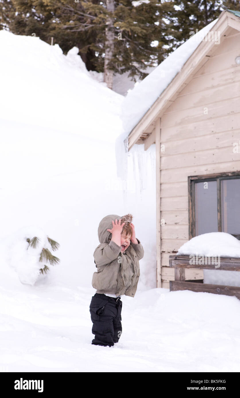 Kleiner Junge spielt im Schnee Stockfoto