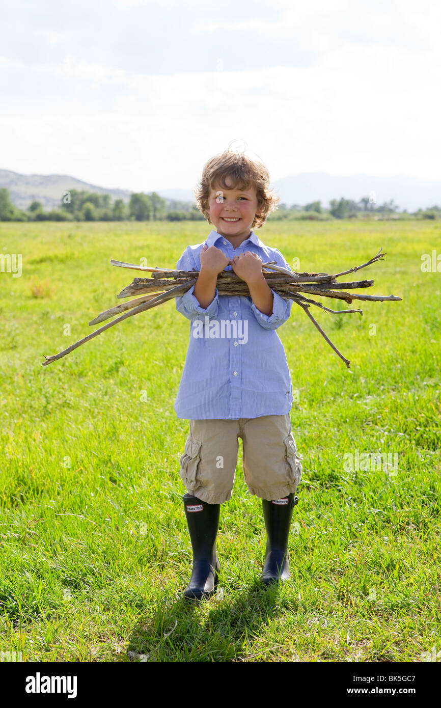 Junge sammeln Stöcke im Feld Stockfoto