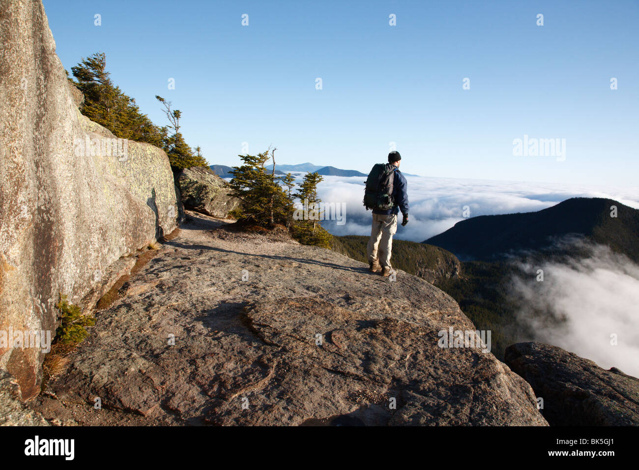 Ein Wanderer nimmt nach Auffassung des Undercast vom Gipfel des Mount Osceola in den White Mountains, New Hampshire, USA Stockfoto