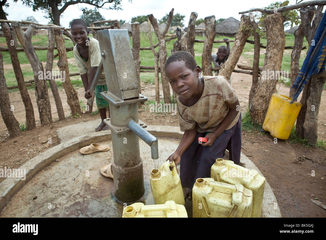 Kinder holen frisches Trinkwasser in einem Bohrloch in Amuria Bezirk, Teso Region, Uganda. Stockfoto